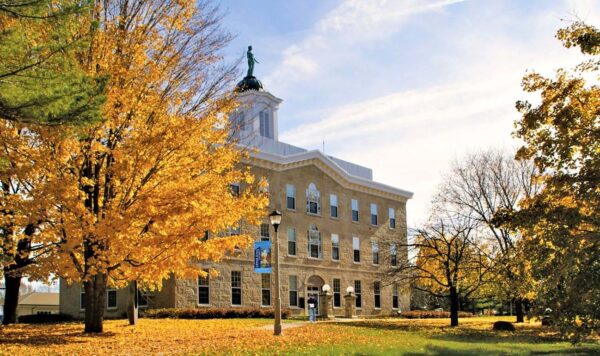 UIU's Alexander-Dickman hall with fall colors in the foreground trees.